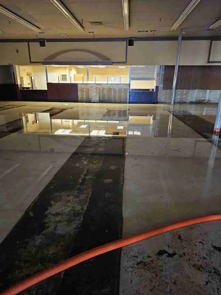 Large commercial floor with standing water and extraction hoses