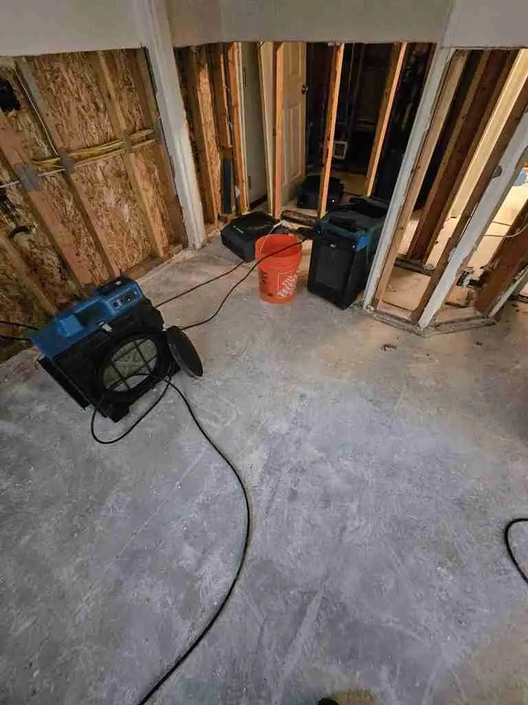 Room with wet drywall removed and a dehumidifier and air movers drying the framing on a Rapid Response job