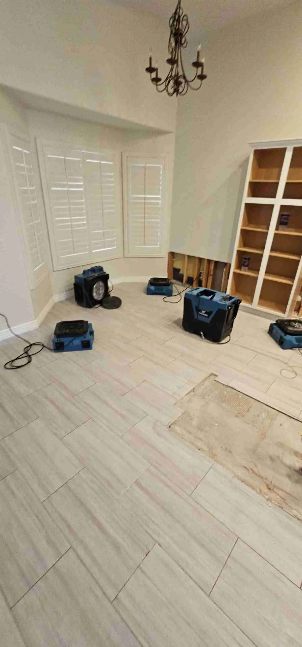 Tile floor opened up with drying equipment set up after a leak in a Rapid Response job